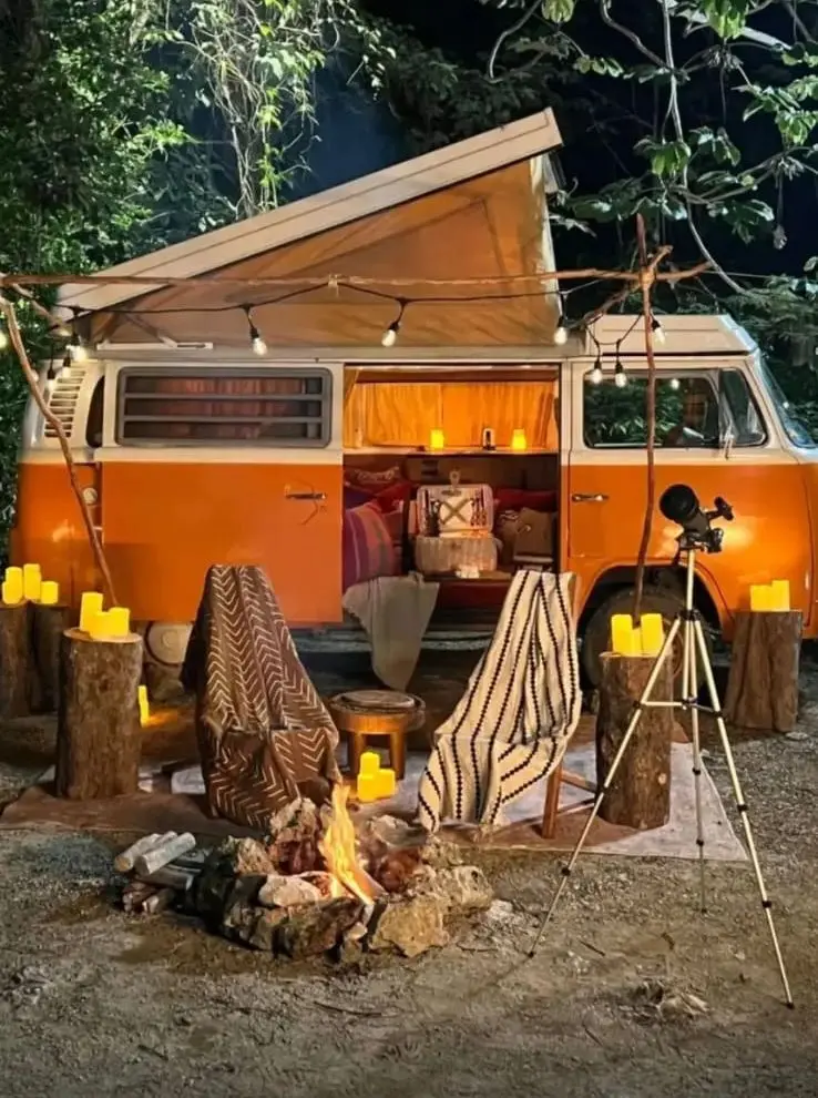Nächtliches Fotoset mit The Orange, Lichterketten, Kerzen, Feuer, Teleskop und Stühlen mit Decken